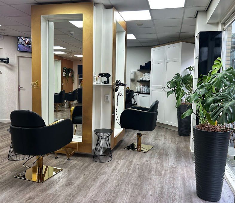Gold-framed mirror styling station with leather chairs